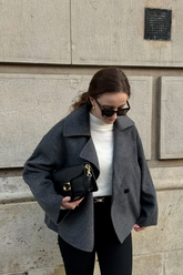 a lady in a white sweater, a grey wool jacket and a pair of black pants